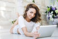 Portrait of a beautiful girl gentle, cute young, lying on the floor, with laptop posing Royalty Free Stock Photo