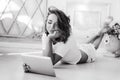 Portrait of a beautiful girl gentle, cute young, lying on the floor, with laptop posing Royalty Free Stock Photo