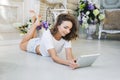 Portrait of a beautiful girl gentle, cute young, lying on the floor, with laptop posing Royalty Free Stock Photo