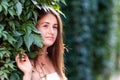 Young woman stands near the wall of green ivy leaves Royalty Free Stock Photo