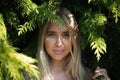 Portrait of a beautiful girl in green leaves