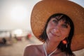 Portrait of a beautiful girl in a hat. Happy beautiful young woman smiling on the beach - Charming girl enjoying a sunny day - Royalty Free Stock Photo