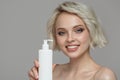 Portrait of a beautiful girl holding a bottle of shampoo conditioner in her hand.