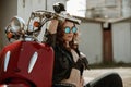 Portrait of a beautiful girl in leather jacket, brassiere and glasses near red motorcycle Royalty Free Stock Photo