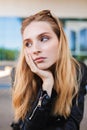 Portrait of beautiful girl in leather jacket with sunglesses on head thoughtfully looking aside