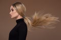 Portrait of beautiful girl with long airy hair. Brown background