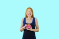 A portrait of a beautiful girl with long red hair who is holding a box with a gift and smiling enthusiastically by Royalty Free Stock Photo