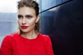 Portrait of a beautiful girl with make-up in a red dress in a modern city, close-up. Royalty Free Stock Photo