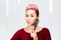 Portrait of beautiful girl with modern hairstyle holding comb