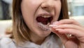 Portrait of beautiful girl patient holding orthodontic retainers aligners in dental clinic.