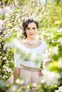 Portrait of beautiful girl posing outdoor with flowers of the cherry trees in blossom during a bright spring day Royalty Free Stock Photo