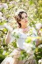 Portrait of beautiful girl posing outdoor with flowers of the cherry trees in blossom during a bright spring day Royalty Free Stock Photo