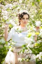 Portrait of beautiful girl posing outdoor with flowers of the cherry trees in blossom during a bright spring day Royalty Free Stock Photo