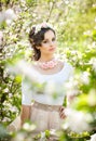Portrait of beautiful girl posing outdoor with flowers of the cherry trees in blossom during a bright spring day Royalty Free Stock Photo