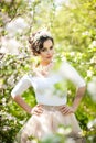 Portrait of beautiful girl posing outdoor with flowers of the cherry trees in blossom during a bright spring day Royalty Free Stock Photo