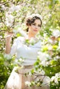 Portrait of beautiful girl posing outdoor with flowers of the cherry trees in blossom during a bright spring day Royalty Free Stock Photo