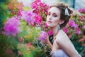 Portrait of a beautiful girl in ryzhoy delicate blue dress, beautifully decorated Moonstone in the lush garden of azaleas.