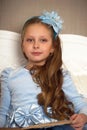 portrait of a beautiful girl of seven years in a blue dress with