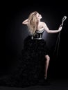 Portrait of a beautiful girl singer in black dress with microphone Royalty Free Stock Photo