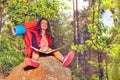 Girl with map sit on stone during hike Royalty Free Stock Photo