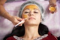 Portrait of beautiful girl applying gold facial mask. Close-up Royalty Free Stock Photo