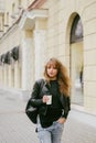 Portrait of a beautiful girl on the street, holding a paper cup