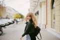 Portrait of a beautiful girl on the street, holding a paper cup