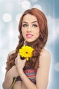 Portrait of beautiful girl in studio with yellow chrysanthemum in her hands. young woman with blue eyes with bright flower Royalty Free Stock Photo