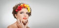 Portrait of beautiful girl in studio with yellow and red roses in her hair and naked shoulders. young woman Royalty Free Stock Photo