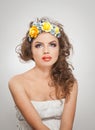 Portrait of beautiful girl in studio with yellow roses in her hair and naked shoulders. young woman with professional makeup Royalty Free Stock Photo