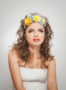 Portrait of beautiful girl in studio with yellow roses in her hair and naked shoulders. young woman with professional makeup Royalty Free Stock Photo