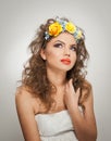 Portrait of beautiful girl in studio with yellow roses in her hair and naked shoulders. young woman with professional makeup Royalty Free Stock Photo