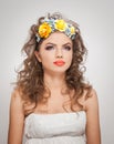 Portrait of beautiful girl in studio with yellow roses in her hair and naked shoulders. young woman with professional makeup Royalty Free Stock Photo