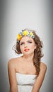 Portrait of beautiful girl in studio with yellow roses in her hair and naked shoulders. young woman with professional makeup Royalty Free Stock Photo