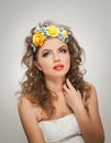 Portrait of beautiful girl in studio with yellow roses in her hair and naked shoulders. young woman with professional makeup Royalty Free Stock Photo