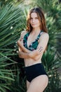 Portrait of a beautiful girl in a swimsuit near palms Royalty Free Stock Photo