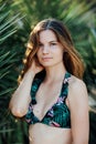 Portrait of a beautiful girl in a swimsuit near palms Royalty Free Stock Photo