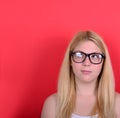 Portrait of beautiful girl thinking and looking up against red b