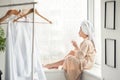 Portrait of beautiful girl and towel on head in bathrobe with a cup, home style relaxation concept after shower Royalty Free Stock Photo