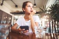 Portrait of beautiful girl using her mobile phone in cafe. Royalty Free Stock Photo