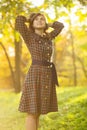 Portrait of a beautiful girl walking in nature in the autumn, a young woman enjoying the sunshine standing on a hill with grass Royalty Free Stock Photo