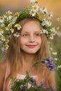 Portrait of a beautiful girl wearing a crown of chamomile. Little girl with a wreath of flowers on her head Royalty Free Stock Photo