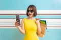 Portrait of beautiful girl wearing dress and sunglasses holding shopping bags Royalty Free Stock Photo