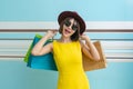Portrait of beautiful girl wearing dress and sunglasses holding shopping bags Royalty Free Stock Photo