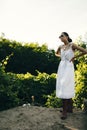 Portrait of a beautiful girl in a white dress in the garden. Burnette beautiful natural girl with in a white dress in