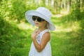Portrait of a beautiful girl in a white hat summer day in the park Royalty Free Stock Photo