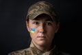 Portrait of beautiful girl with yellow and blue ukrainian flag on her cheek wearing military uniform. Ukrainian women in the army Royalty Free Stock Photo