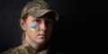 Portrait of beautiful girl with yellow and blue ukrainian flag on her cheek wearing military uniform. Ukrainian women in the army Royalty Free Stock Photo