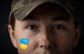 Portrait of beautiful girl with yellow and blue ukrainian flag on her cheek wearing military uniform. Ukrainian women in the army Royalty Free Stock Photo