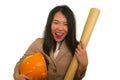 Portrait of beautiful and happy Asian Chinese woman with hardhat holding building blueprints as architect engineer or constructor Royalty Free Stock Photo